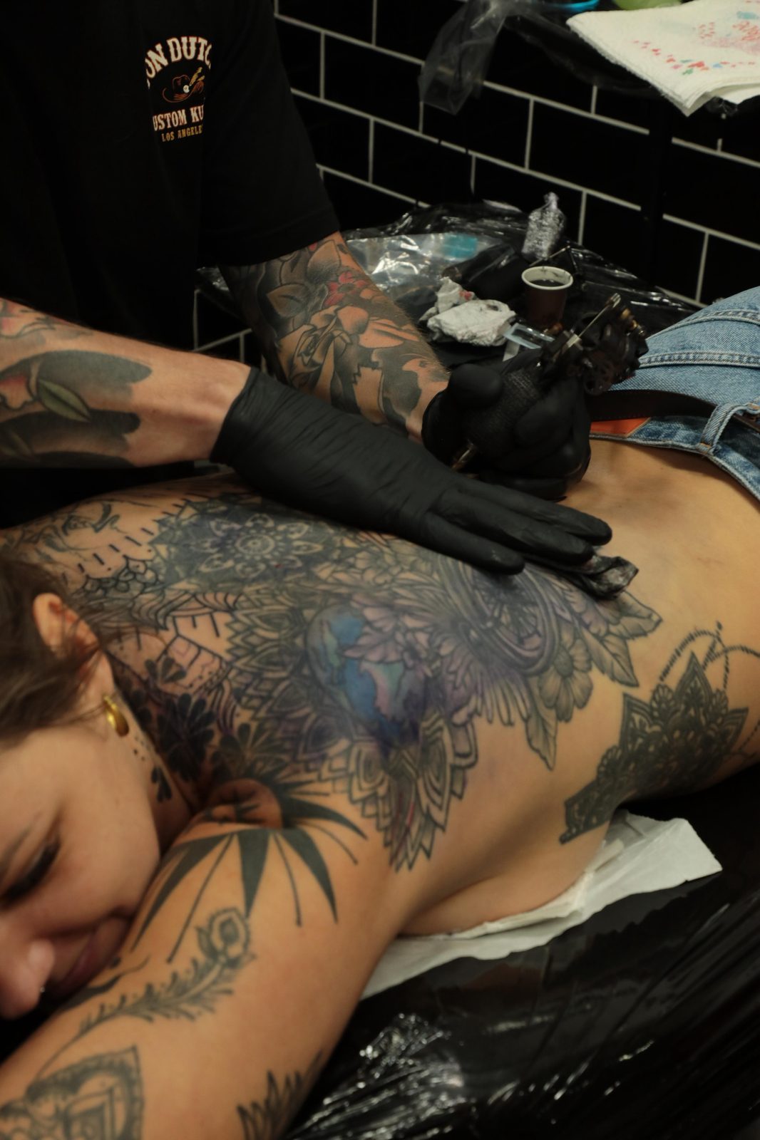 Large blackwork back tattoo in progress during a session with Scotty Massa