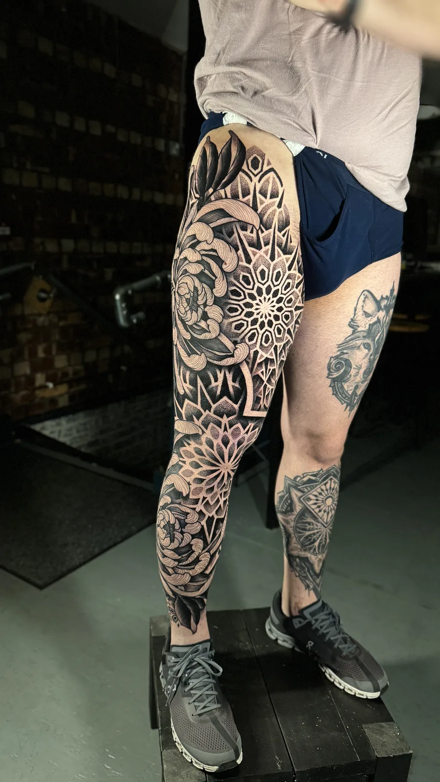 Full leg sleeve of chrysanthemum blooms woven through dotwork mandalas by Scotty Massa