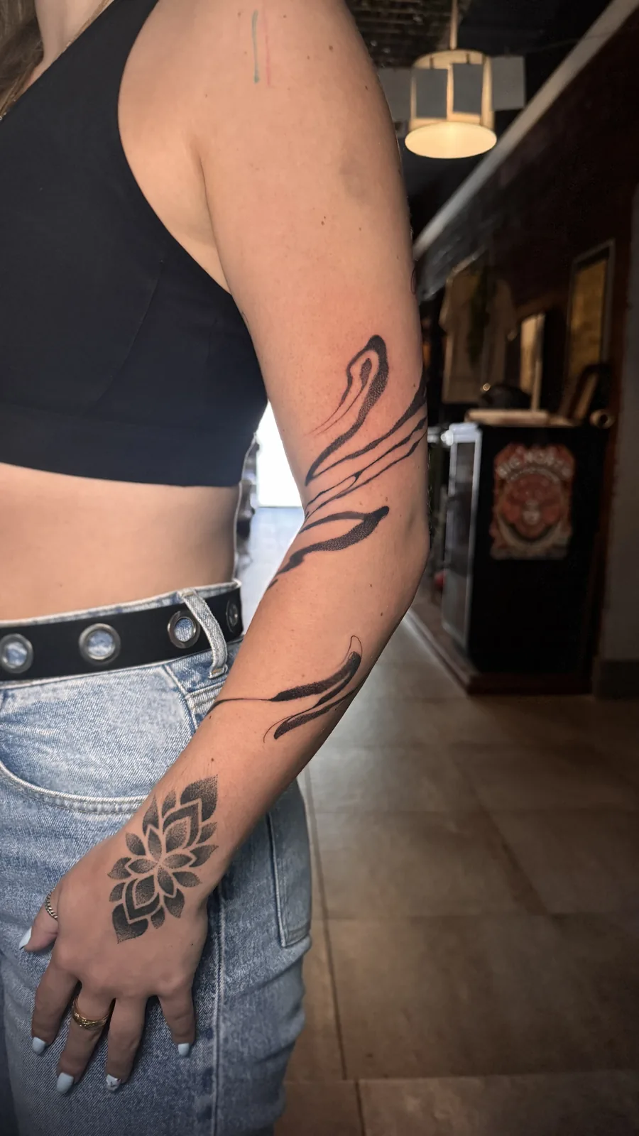 Suminagashi paper-marbling inspired flowing ink tattoo along the arm by Scotty Massa