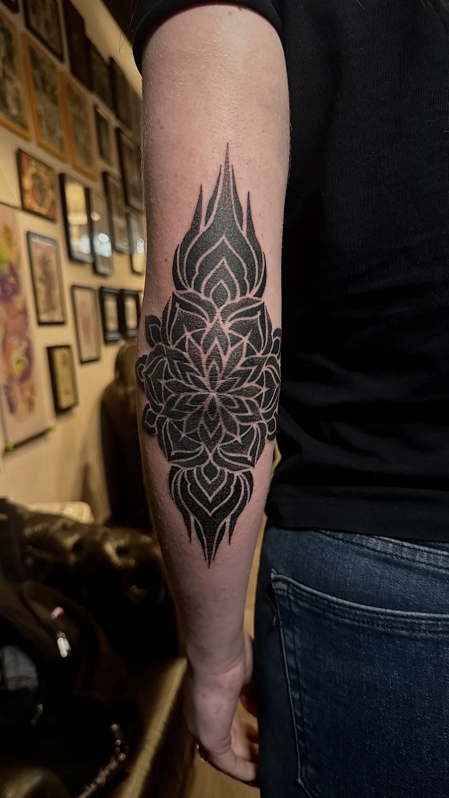 Solid blackwork ornamental mandala on the elbow and forearm, tattoo by Scotty Massa