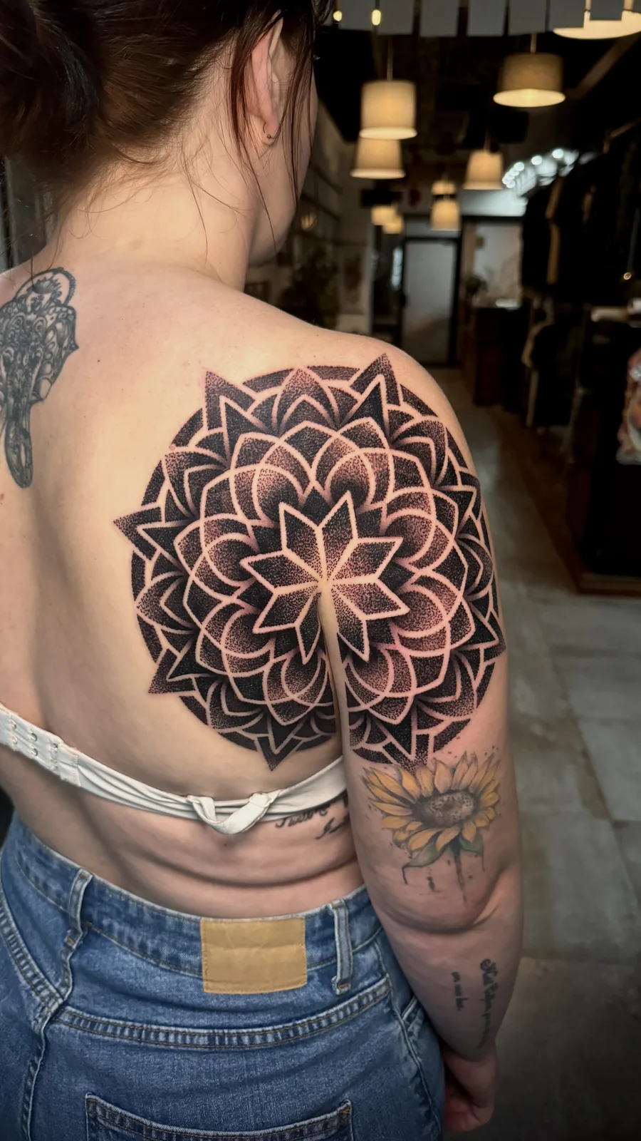 Dotwork mandala tattoo spanning the shoulder blade and upper arm by Scotty Massa