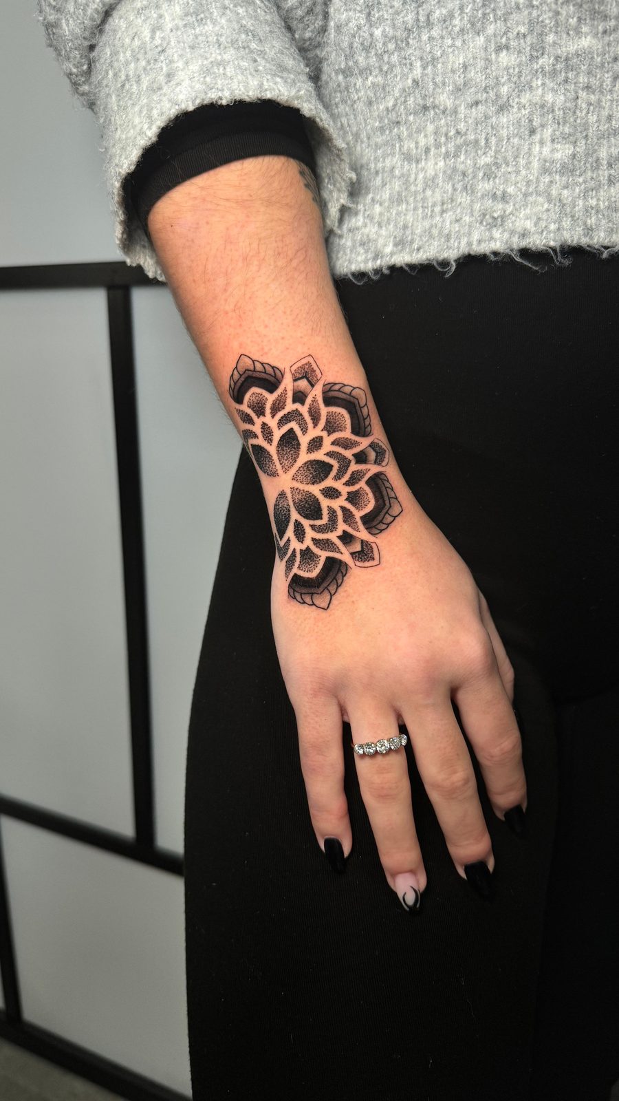 Dotwork mandala tattoo settling across the wrist and onto the back of the hand by Scotty Massa